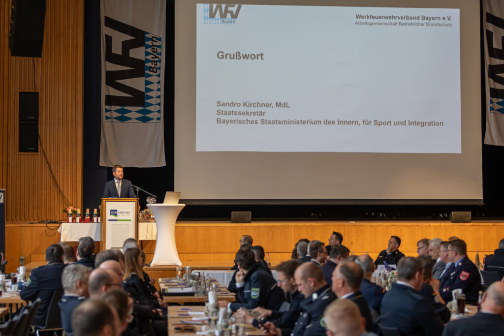 1: Sandro Kirchner, MdL, Staatssekretär des Bayerischen Staatsministerium des Inneren, für Sport und Integration, richtet seine Grußworte an den sehr gut gefüllten Saal im Kurhaus Bad Aibling